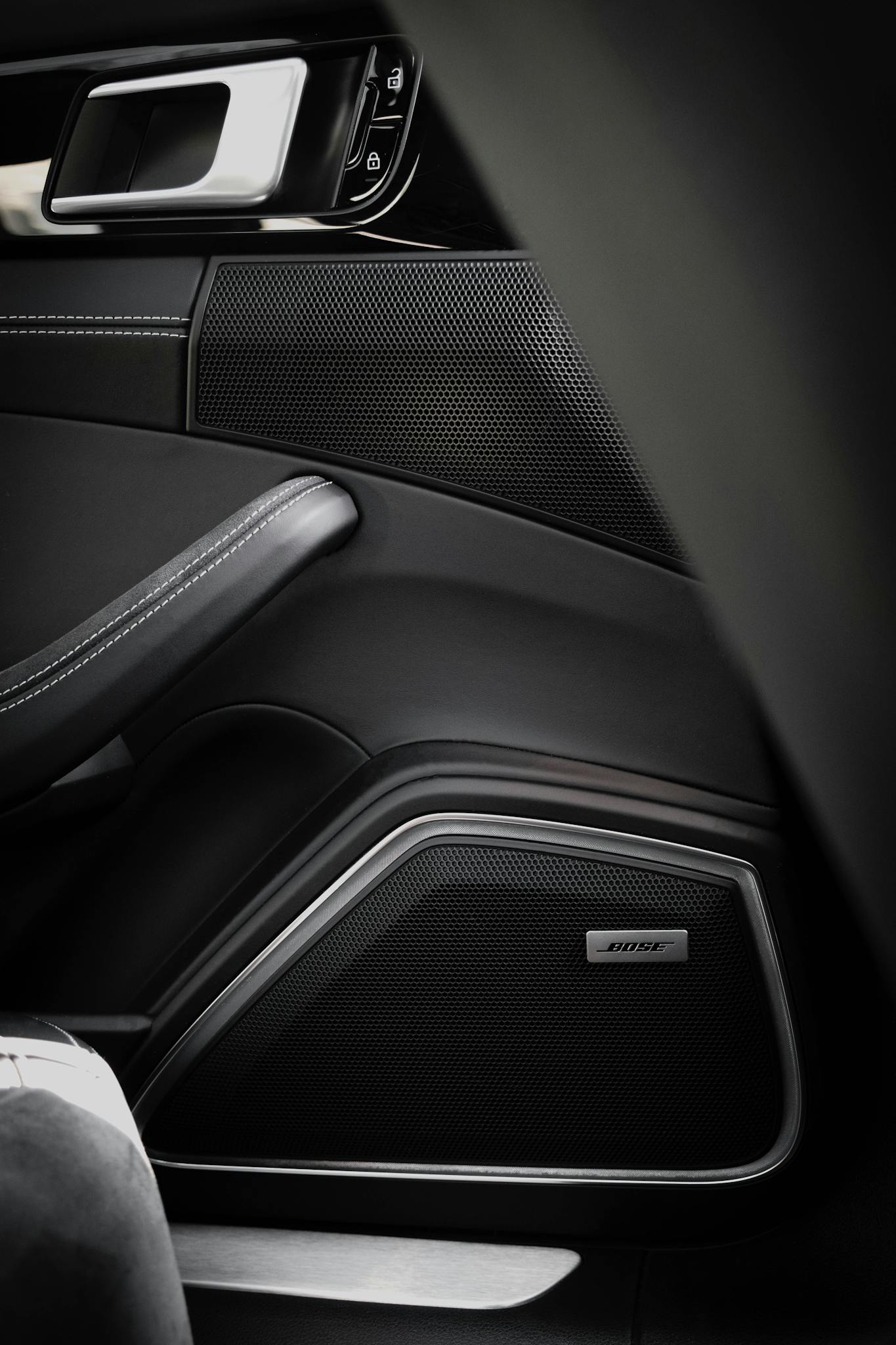 Detailed view of a modern car speaker system integrated into a door panel.