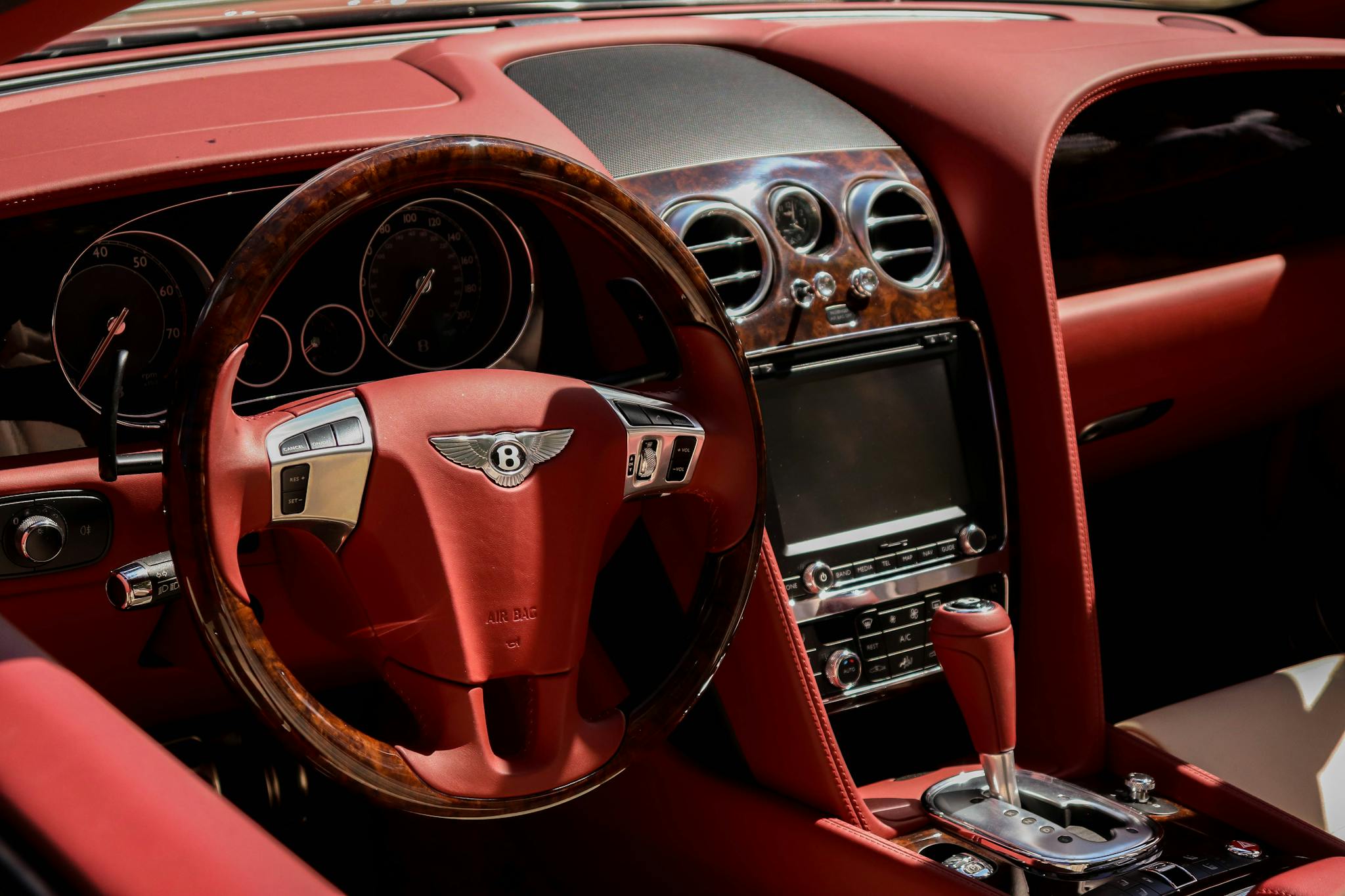 Explore the luxurious and elegant interior of a Bentley with its classic dashboard and red leather accents.